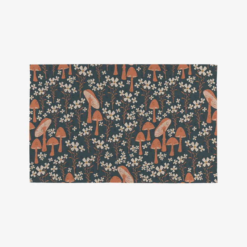 A spruce green Not Paper Towel printed with orange and pink mushrooms and flowers.