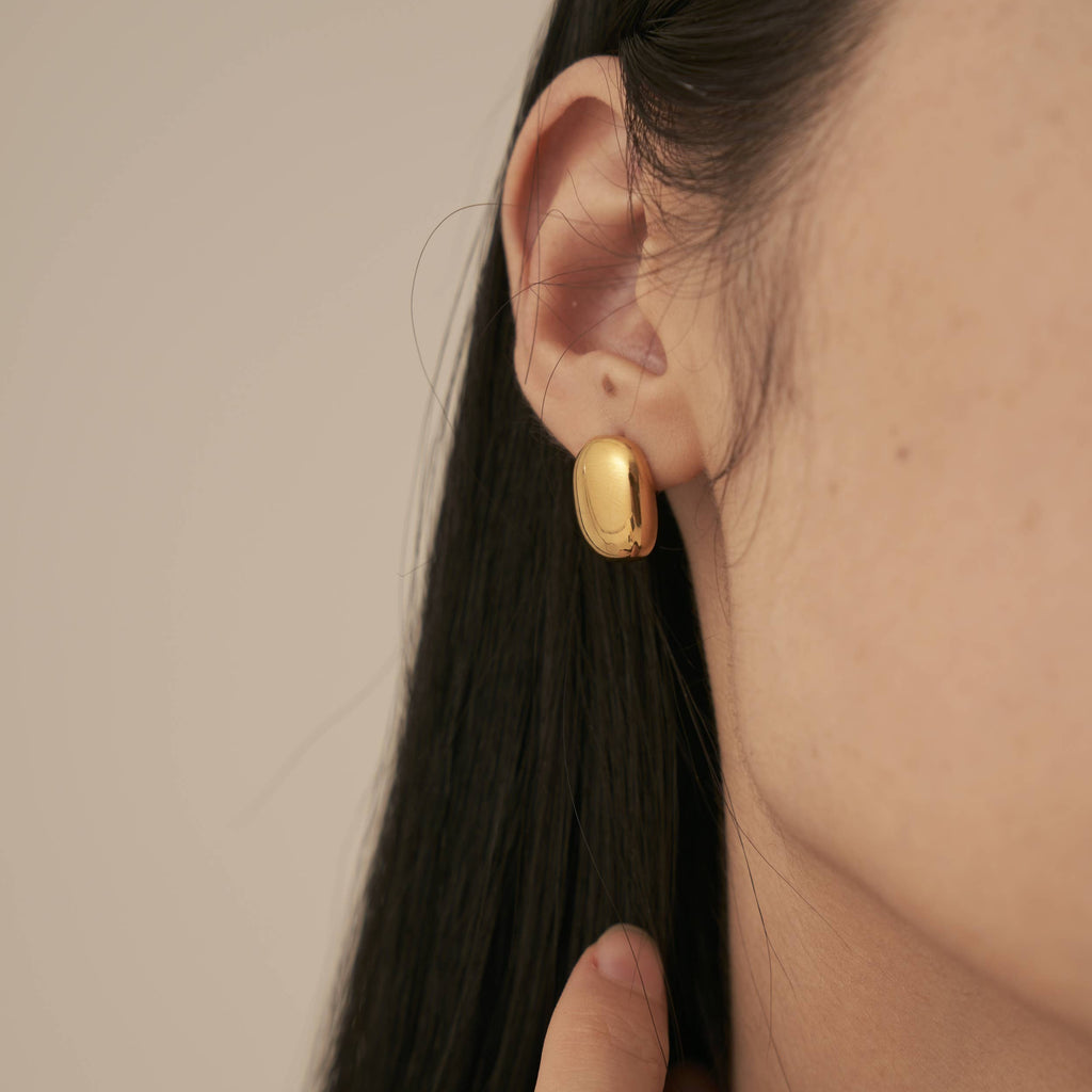 A person wearing the Glossy Square Stud Earrings.