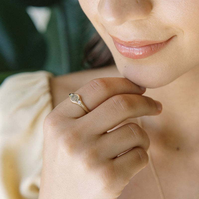 A person wearing the Flora Signet Ring in Gold.