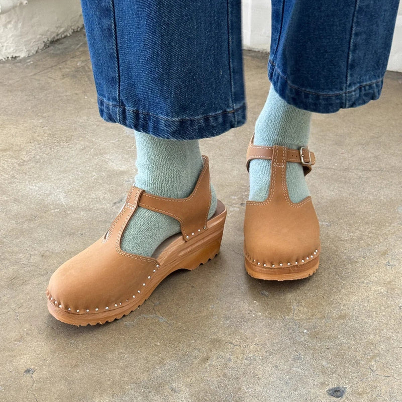 A person wearing the Cloud Socks in Bay with brown clogs and jeans.