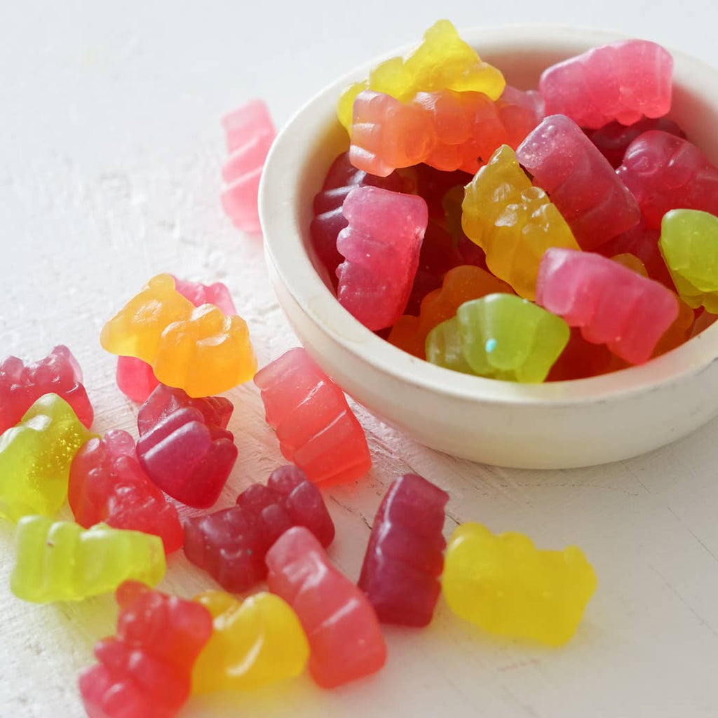 A bowl of pink, red, green, orange, and yellow gummy bears.