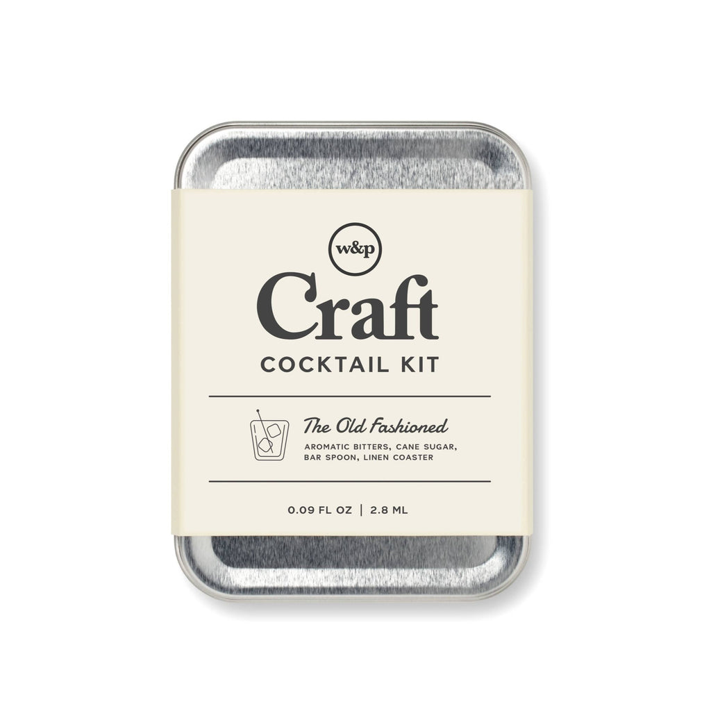 A silver tin in a paper bellyband that says "Craft Cocktail Kit: The Old Fashioned."