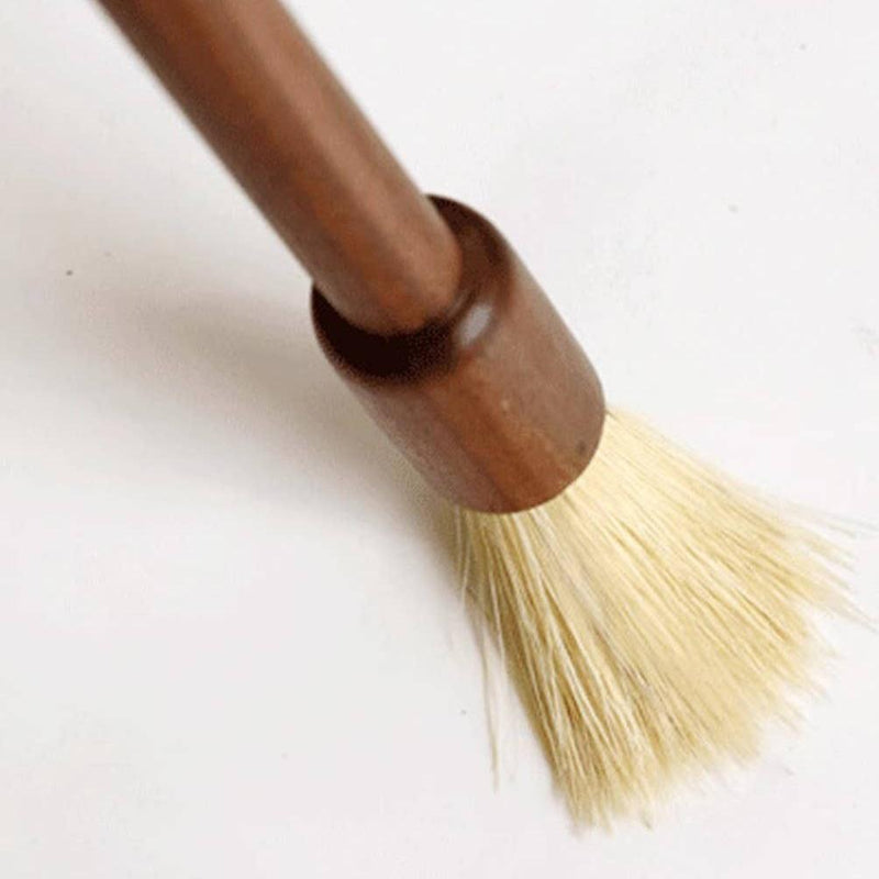 The Baking Tools Brush pressing down on a white counter.