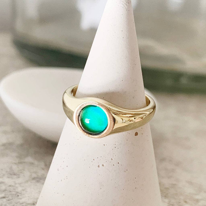 A Signet Mood Ring in Gold resting on a white ceramic cone.