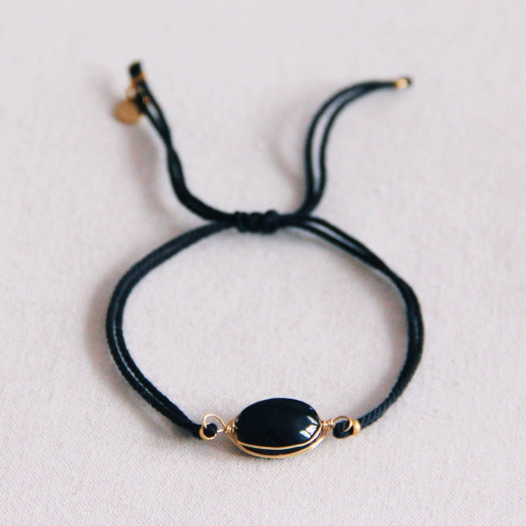 A black cord bracelet with a gold stainless steel wrapped obsidian stone.