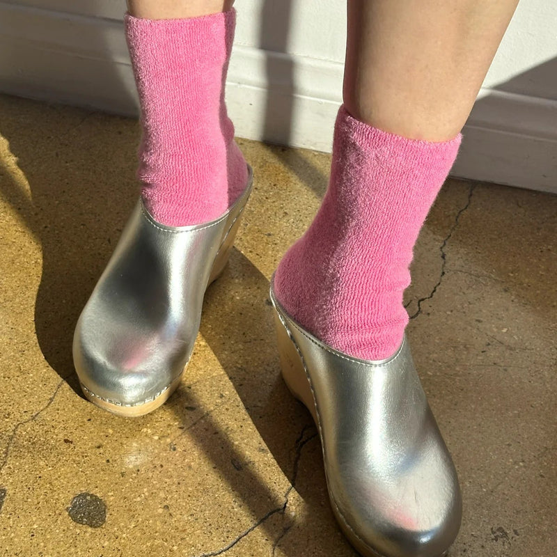 A person wearing their Cloud Socks in Bubble Gum with silver clogs.