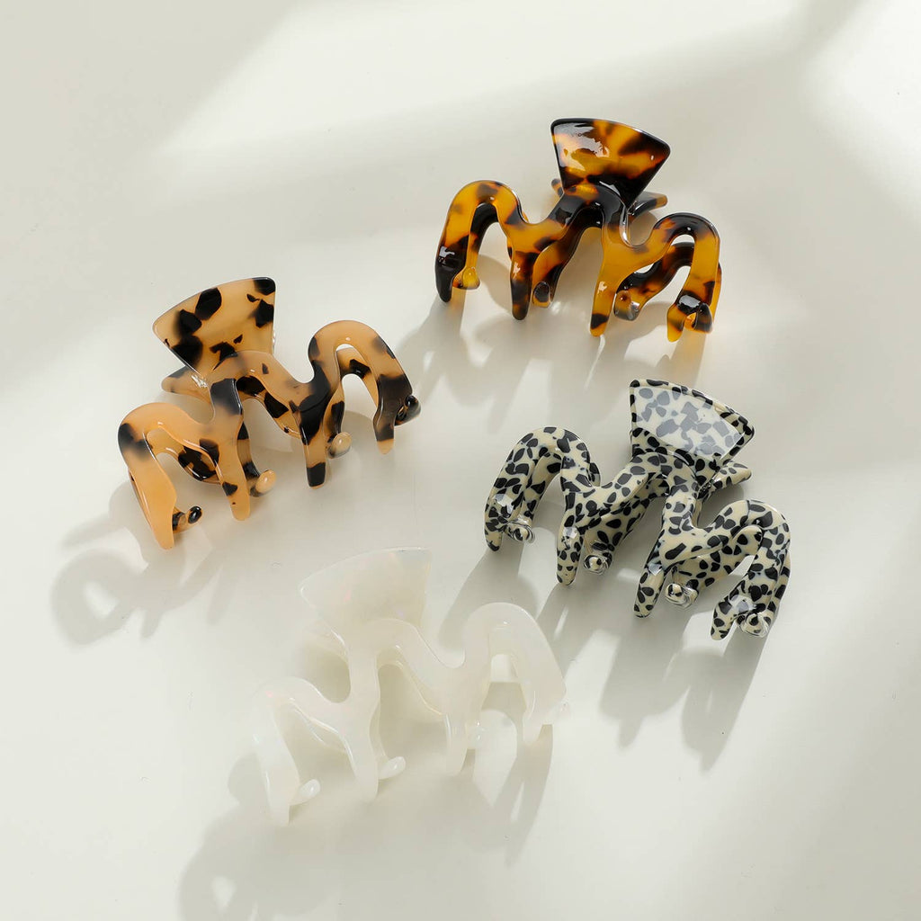 Four wavy style claw clips each with different cellulose acetate patterns.