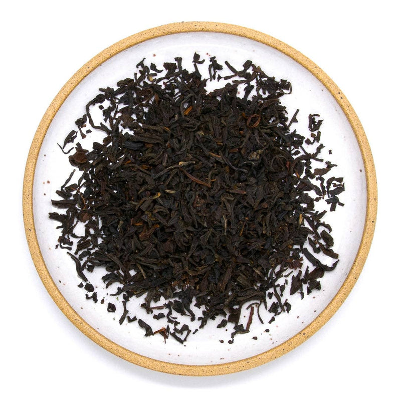 A ceramic plate filled with earl grey tea leaves.