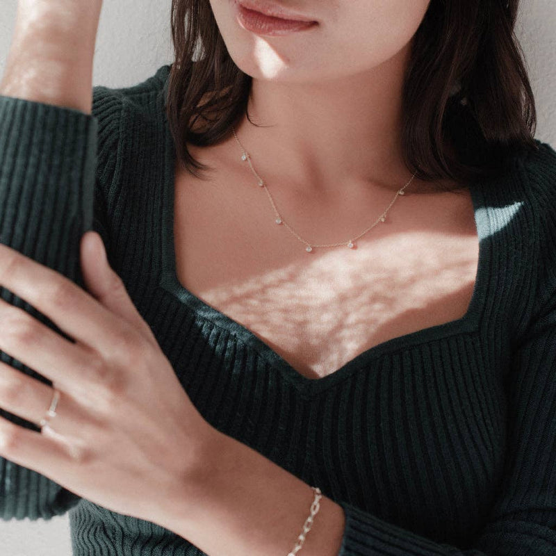 A person wearing the Crystal Stardust Necklace in a silver colorway.