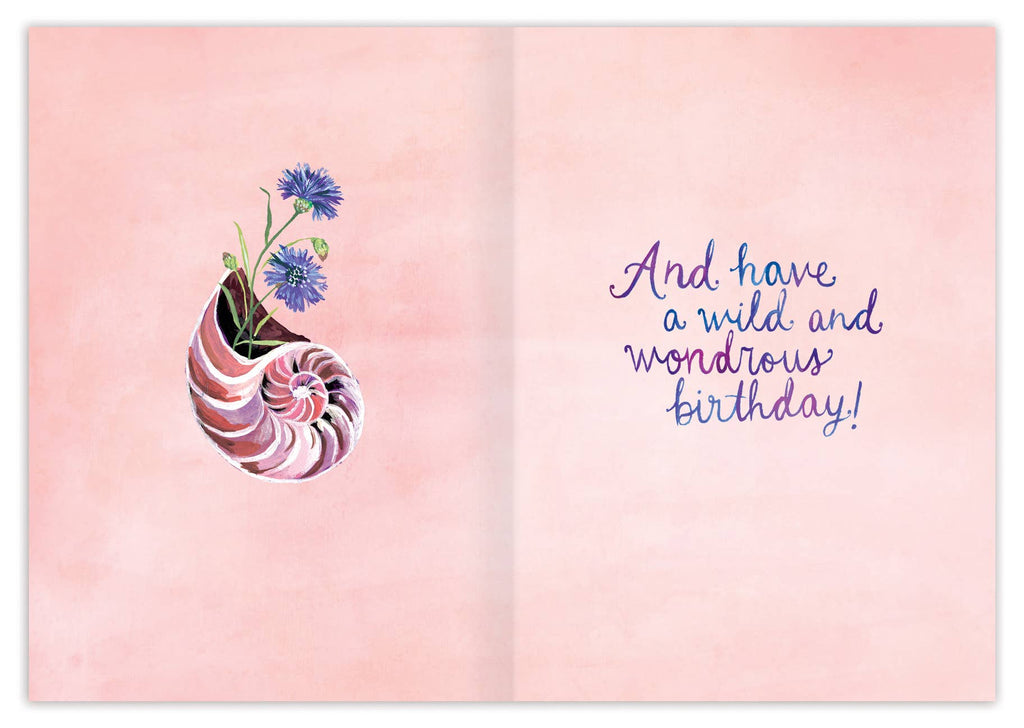 The pink inside of the card featuring flower growing out of a shell on the left and on the right the words "And have a wild and wondrous birthday!"