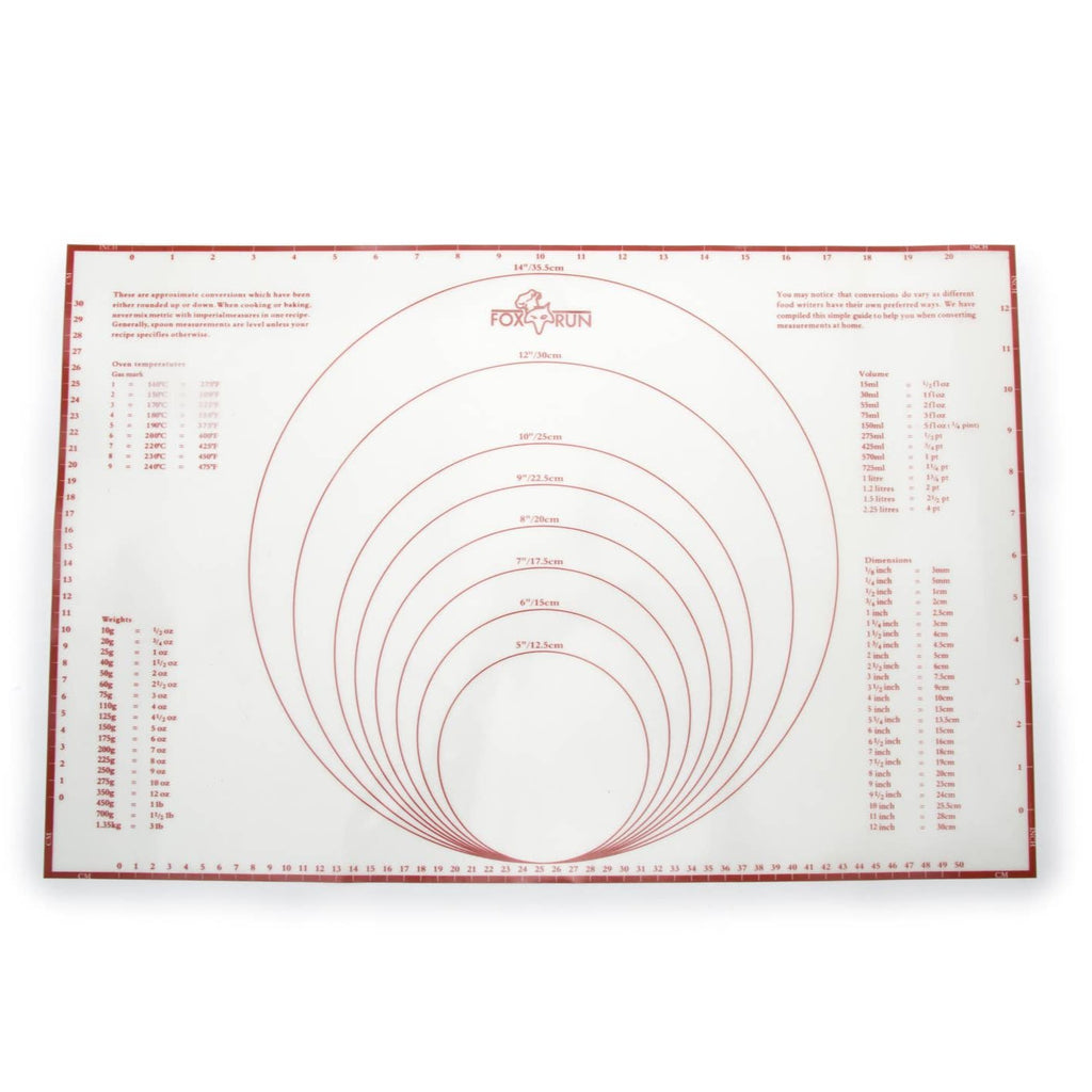 A white and red baking mat with guidelines and measurements written out on the mat.