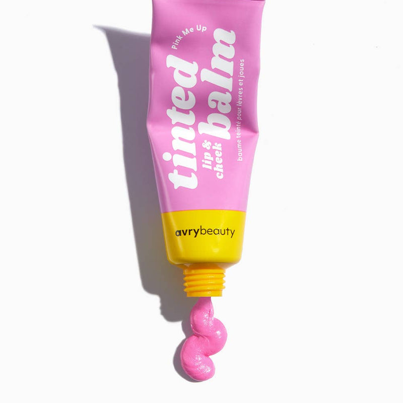 A pink and yellow tube of Pink Me Up Tinted Balm with a squiggle of pink balm squeezed out the bottom.