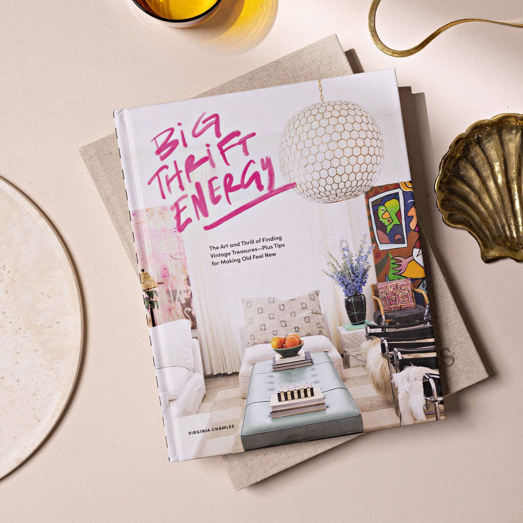 The book cover for Big Thrift Energy which has a styled living room with the words "Big Thrift Energy: The Art and Thrill of Finding Vintage Treasures-- Plus Tips for Making Old Feel New by Virginia Chamlee."