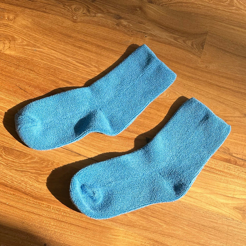 A pair of fluffy teal blue socks.