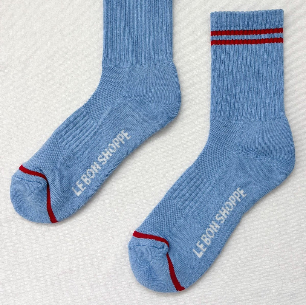 Long sky blue  socks with red stripes above the ankle and at the toe.