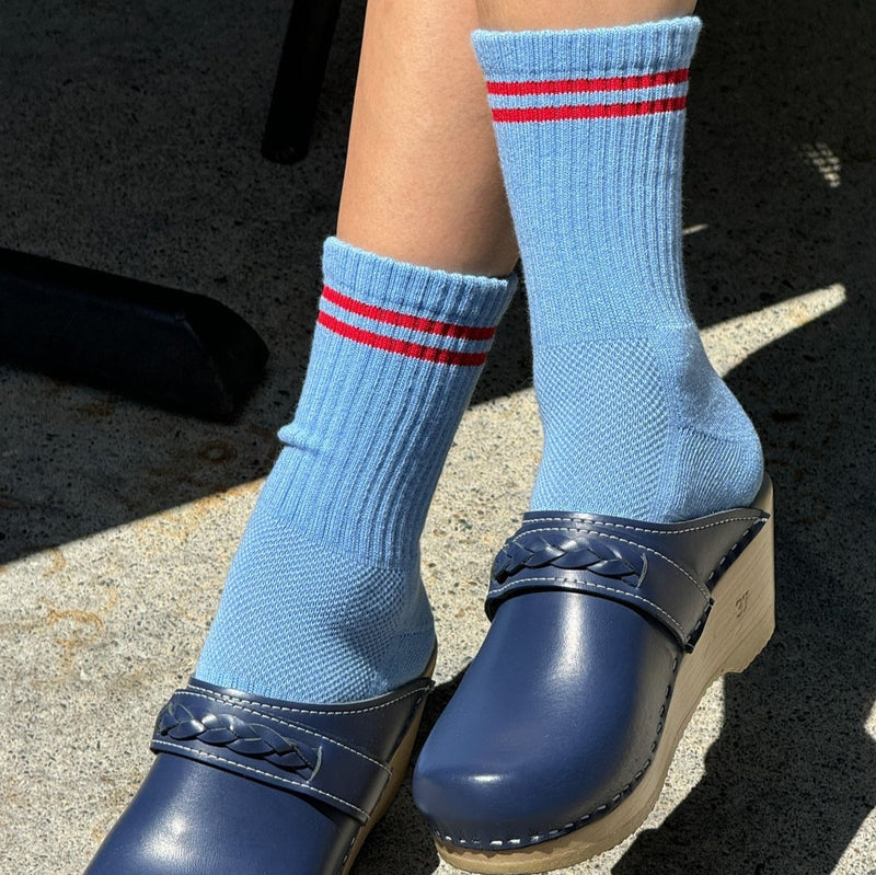 A person wearing the Ciel Blue Boyfriend Socks with blue clogs.