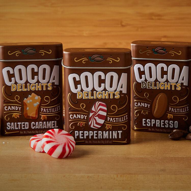 Three Cocoa Delights tins in Salted Caramel, Peppermint, and Espresso flavors.