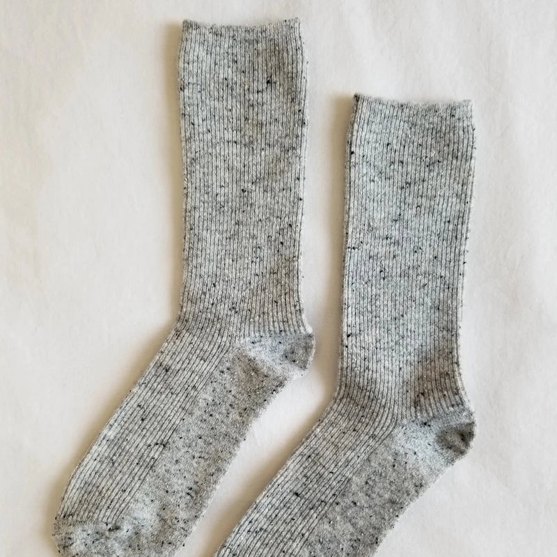 A pair of calf length gray and black speckled socks.