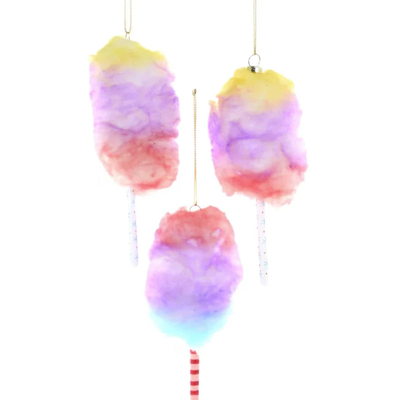 Three pastel ornaments with paper sticks and cotton candy fluffy hanging on a gold cord.