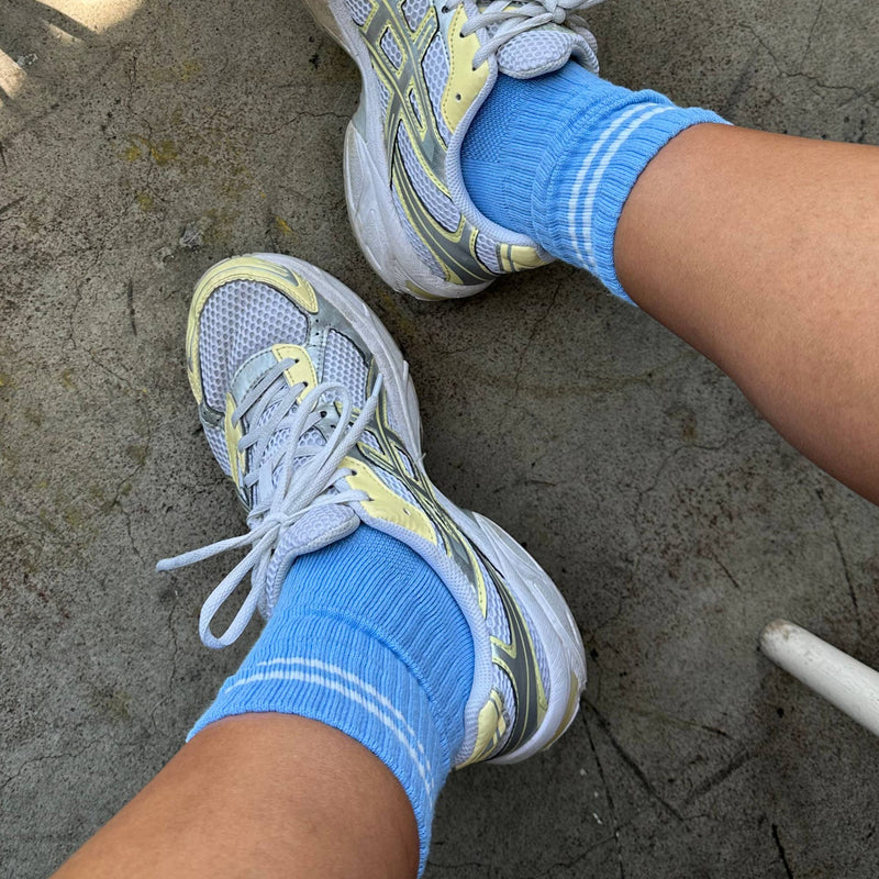 A person wearing the Boyfriend Socks in French Blue with white and yellow gym shoes.