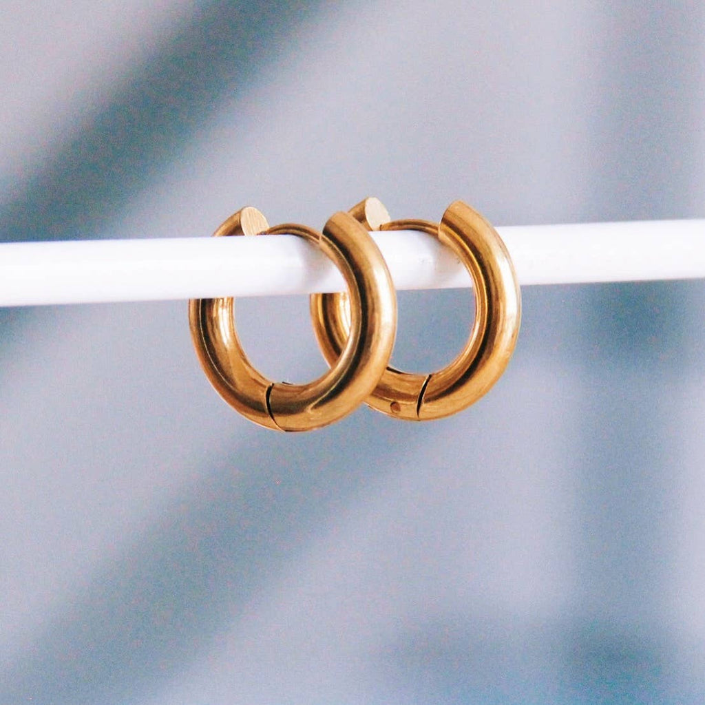 Two thick gold hoops that hug close to the ear and close with a hinged closure.