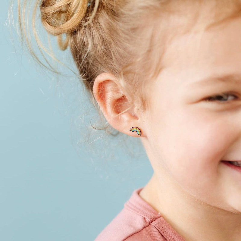 A young girl wearing the Pastel Rainbow Stud Earrings while smiling.