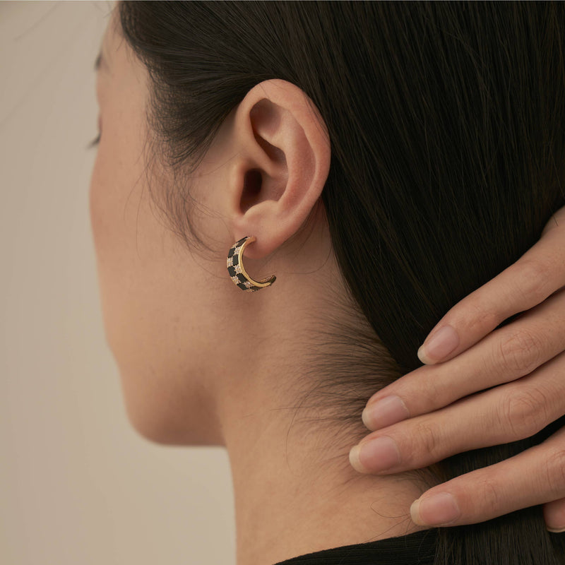 The back view of someone wearing the Black and White Checker Stud Earrings.