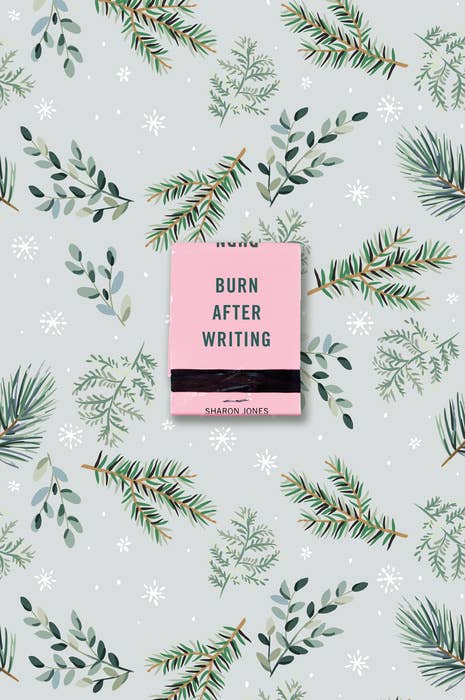 A pale green book illustrated with winter evergreen branches and a pink matchbook with the words "Burn After Writing by Sharon Jones" across the center.