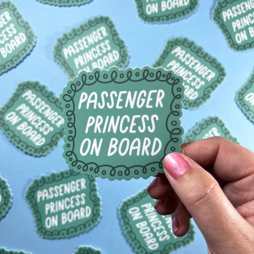 A green sticker that reads "Passenger Princess on Board" with darker green flourishes around it.