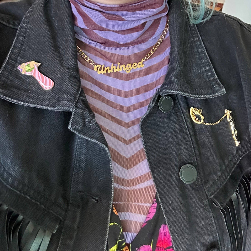 A person wearing the Unhinged Nameplate Necklace with a turtleneck.