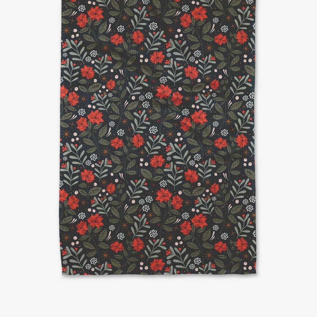 A spruce green tea towel printed with green and red holiday florals.