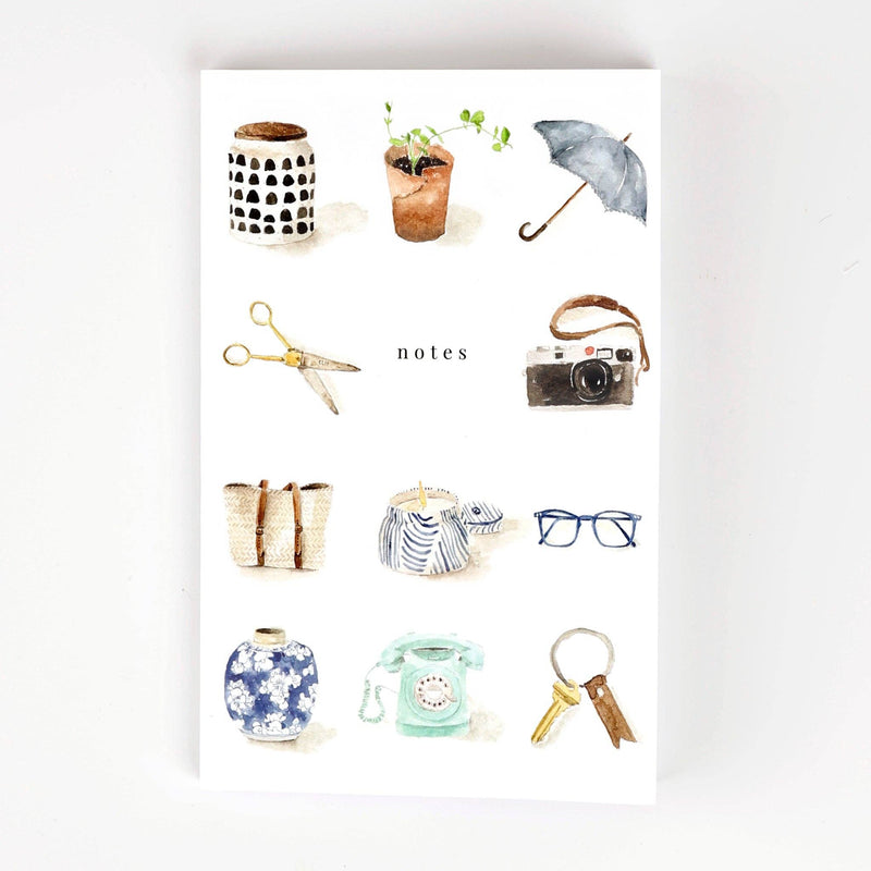 A white notebook watercolor illustrated with a jar, a potted plant, an umbrella, scissors, a film camera, a beach bag, a candle , glasses, a vase, a telephone, and a key ring around the word "notes".