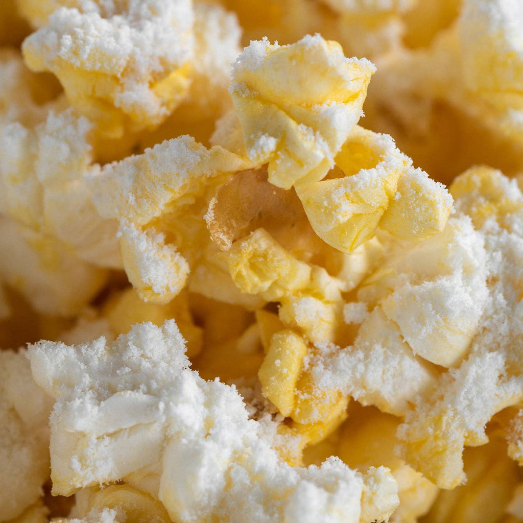 Fresh popped popcorn with white cheddar cheese dust sprinkled on it.