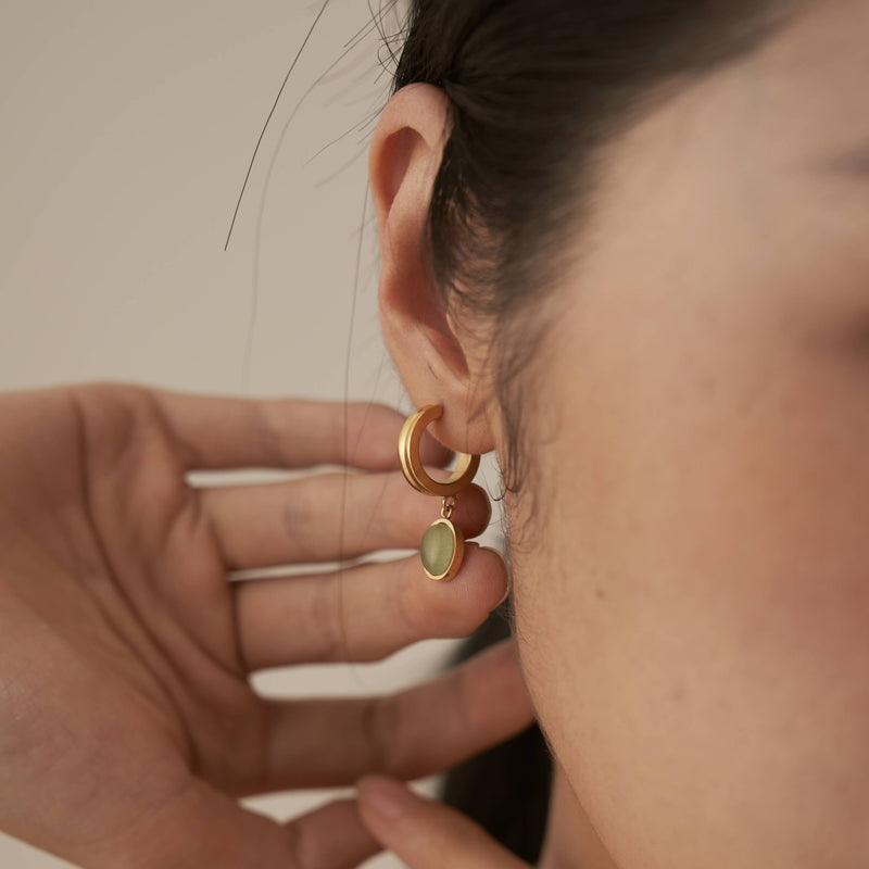 A person holding their hand up to the back of the Aventurine Hoop Earrings.