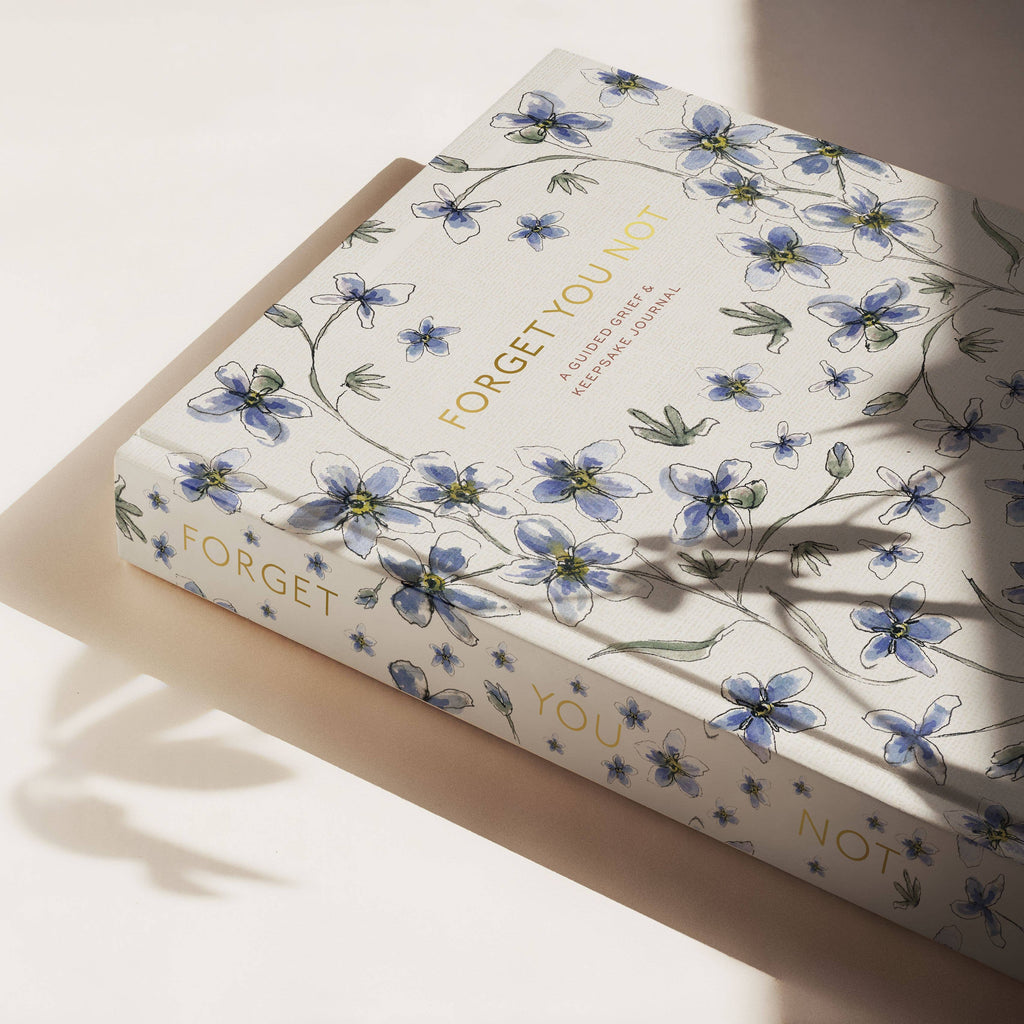 A view of Forget You Not's spine which continues the forget-me-not-illustrations and gold foil text.