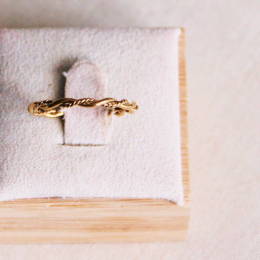 A Braided Ring sitting in a pale pink jewelry holder.