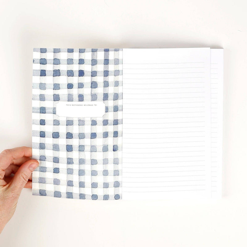 The inside front cover with watercolor painted blue gingham and a place to write the notebook owner's name. The opposite side is white lined paper.