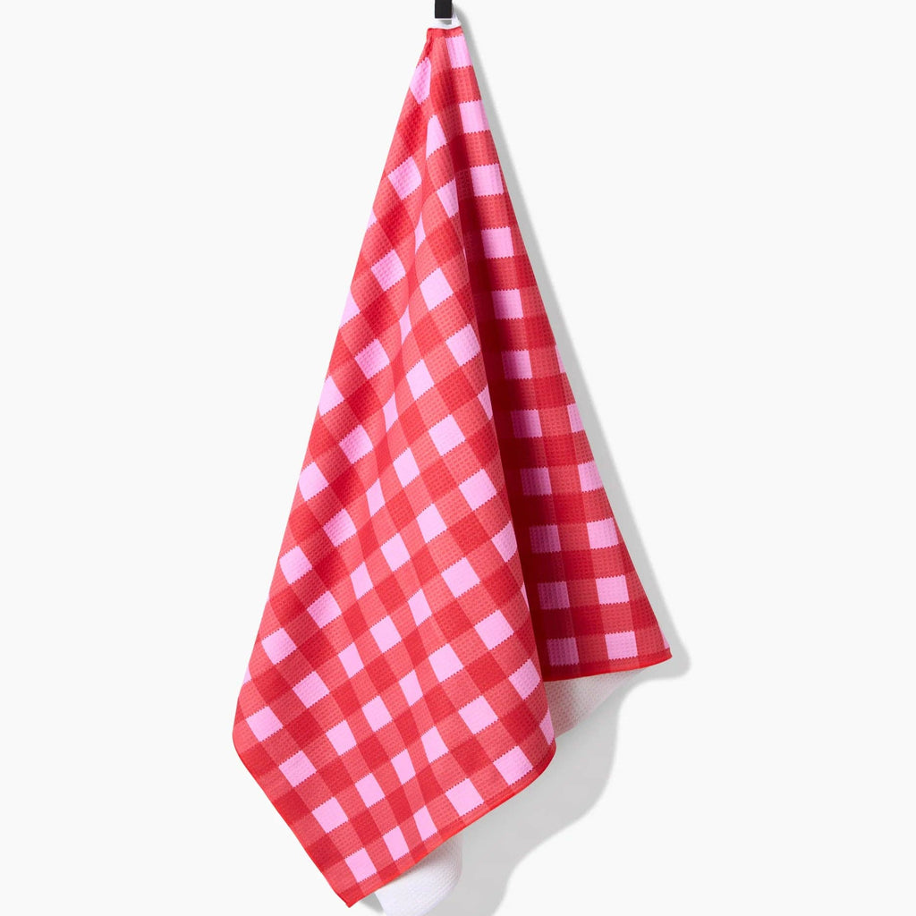 A Cherry Gingham Bath Towel hanging from a hook.