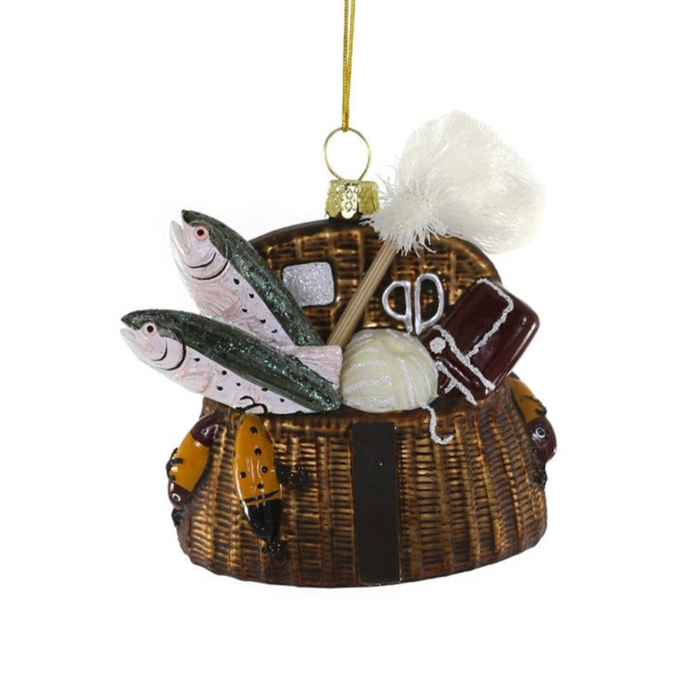 A glass ornament that looks like a basket filled with fishing gear and fish and has a gold cord for tree hanging.