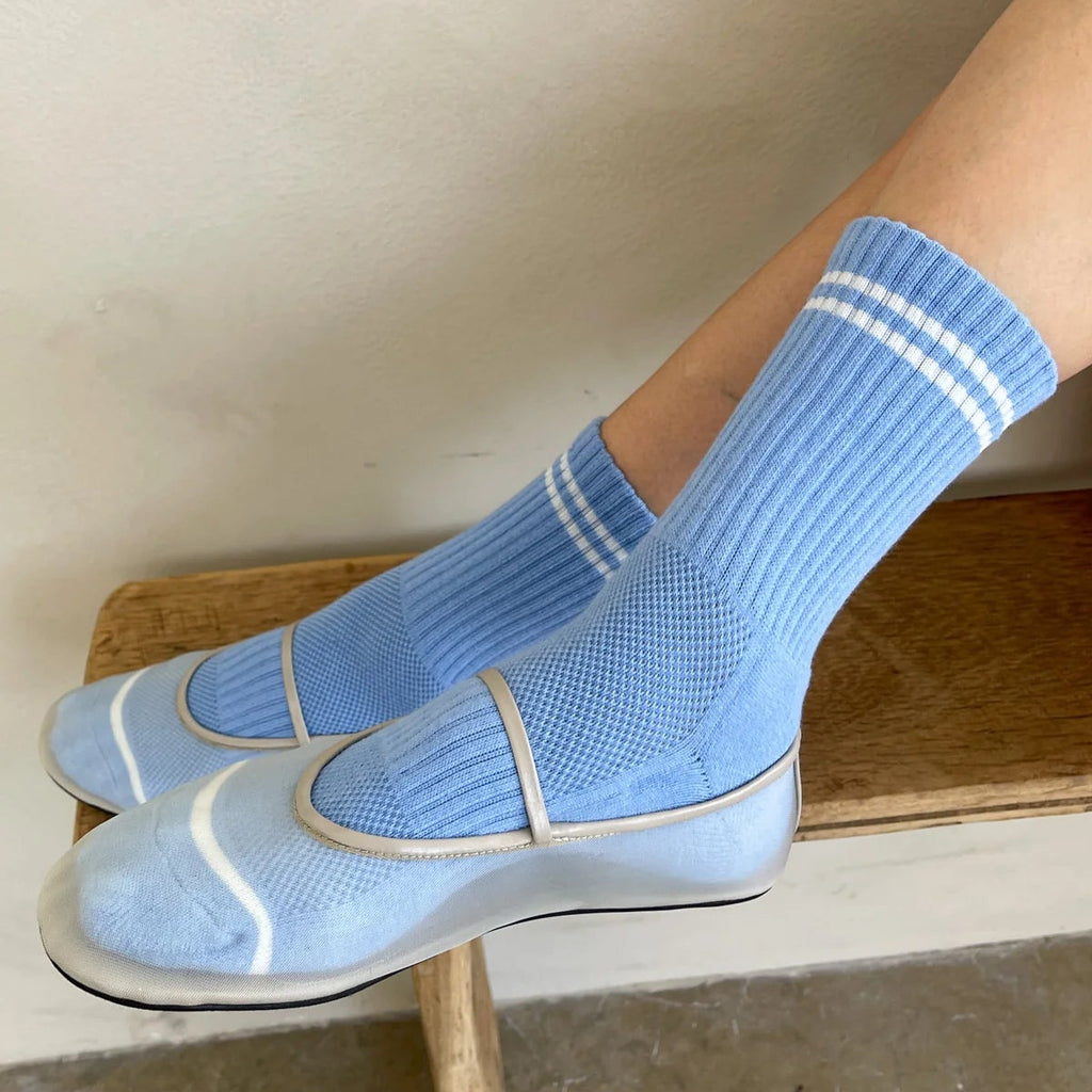 A person wearing the Boyfriend Socks in French Blue with a pair of clear flats.