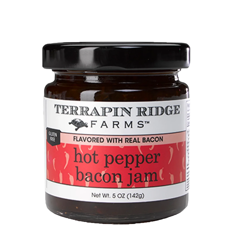 A clear jar of Hot Pepper Bacon Jam with a black lid.