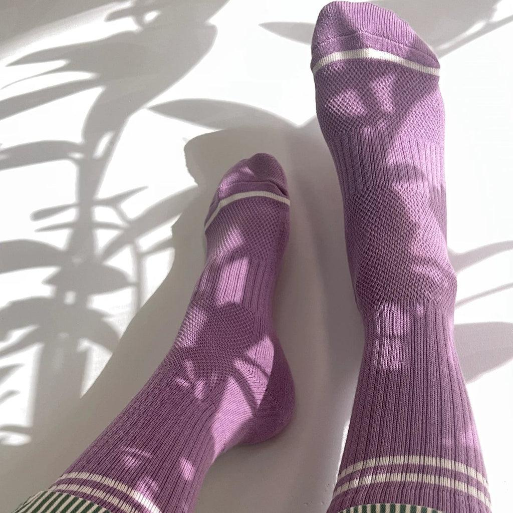 A person wearing the Boyfriend Socks in Grape with striped pants.