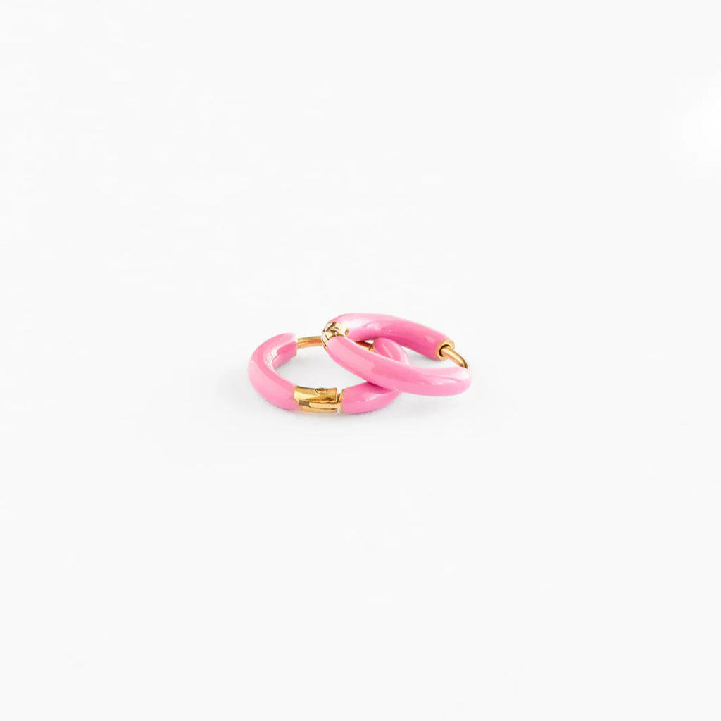 A pair of pink enamel huggie hoops with gold plated hardware.