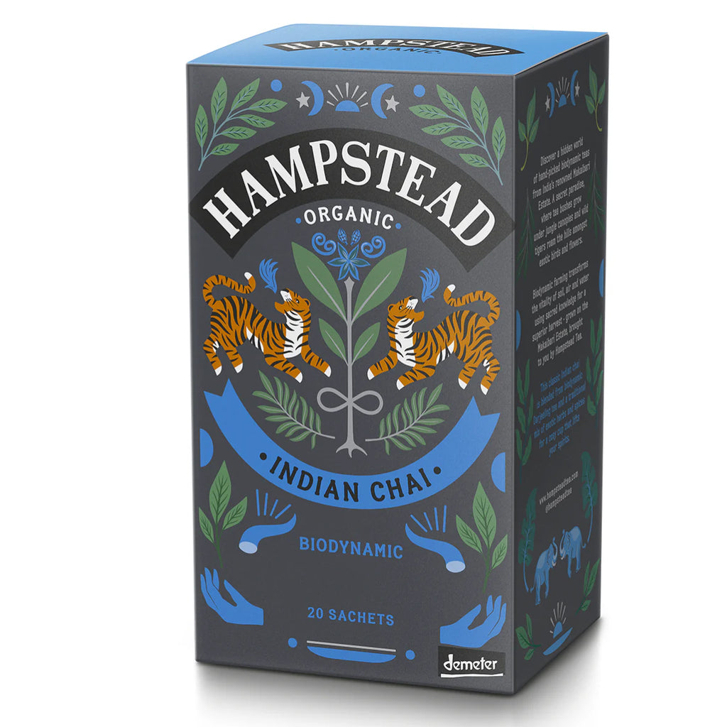 A dark gray and blue box of Hampstead Organic Indian Chai with illustrations of tigers, foliage, and celestial bodies.