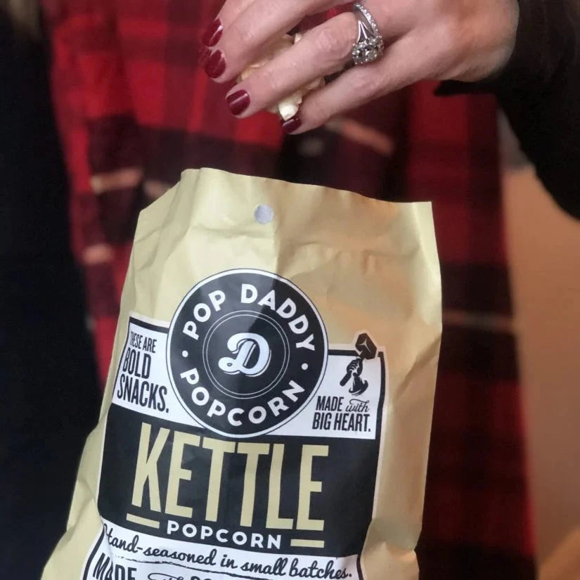 A hand taking out a handful of kettle popcorn.