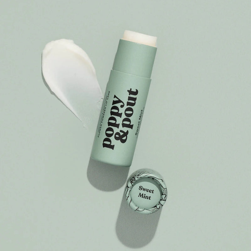 An open mint green tube of Sweet Mint lip balm next to its cap and a swatch of the lip balm.