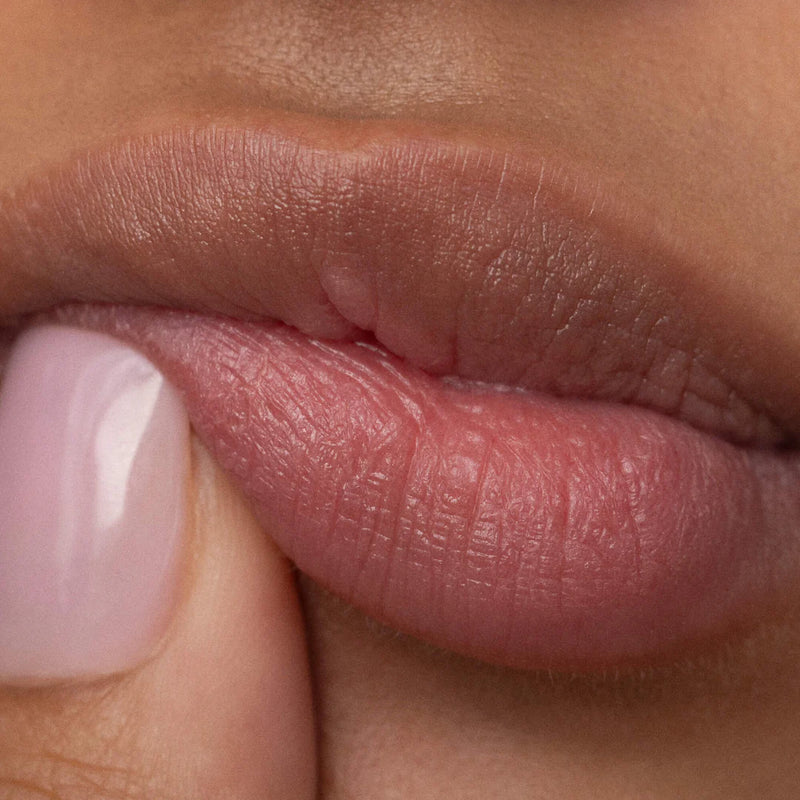 A close-up of someone pushing their bottom lip up with their finger.