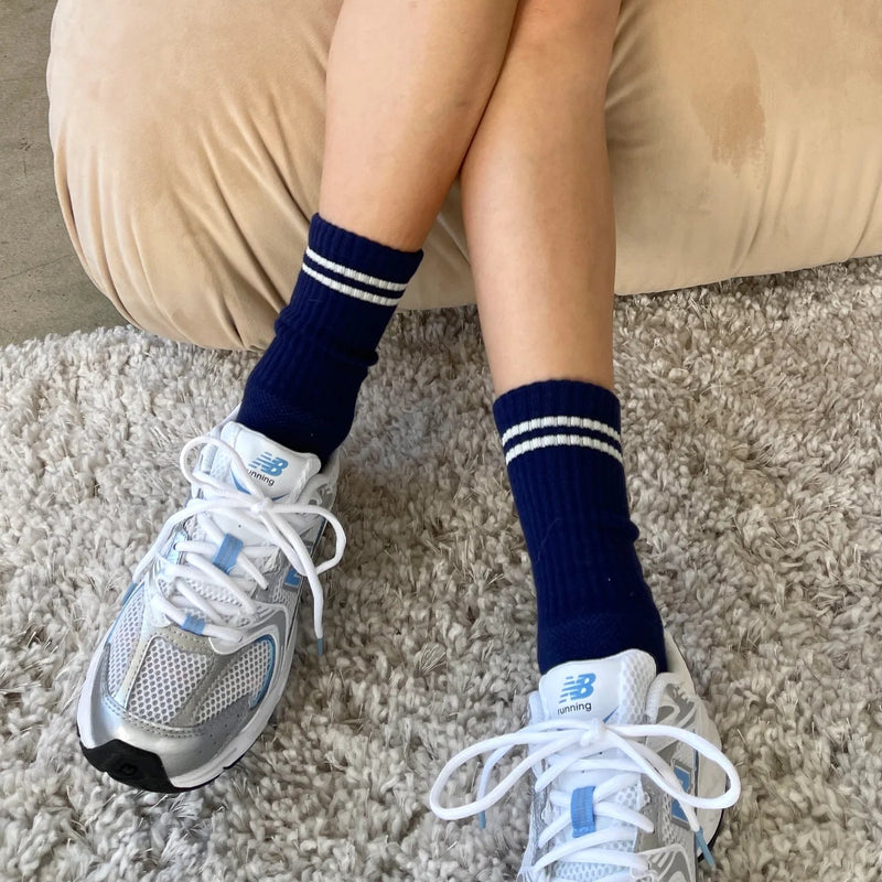 A person wearing the Boyfriend Socks in Navy with gym shoes.