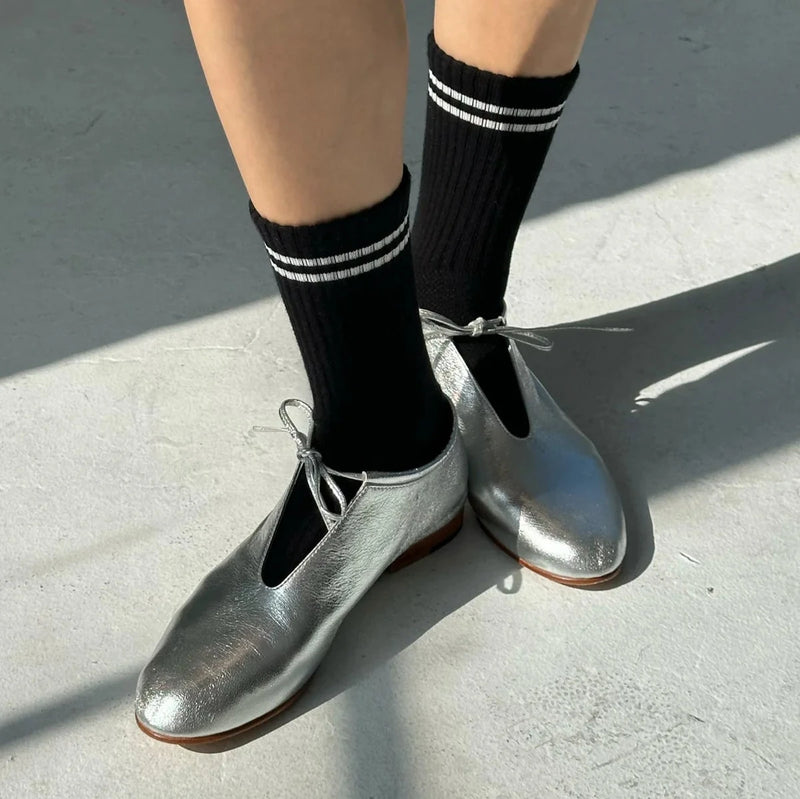 A person wearing the Noir Boyfriend Socks with silver flats.