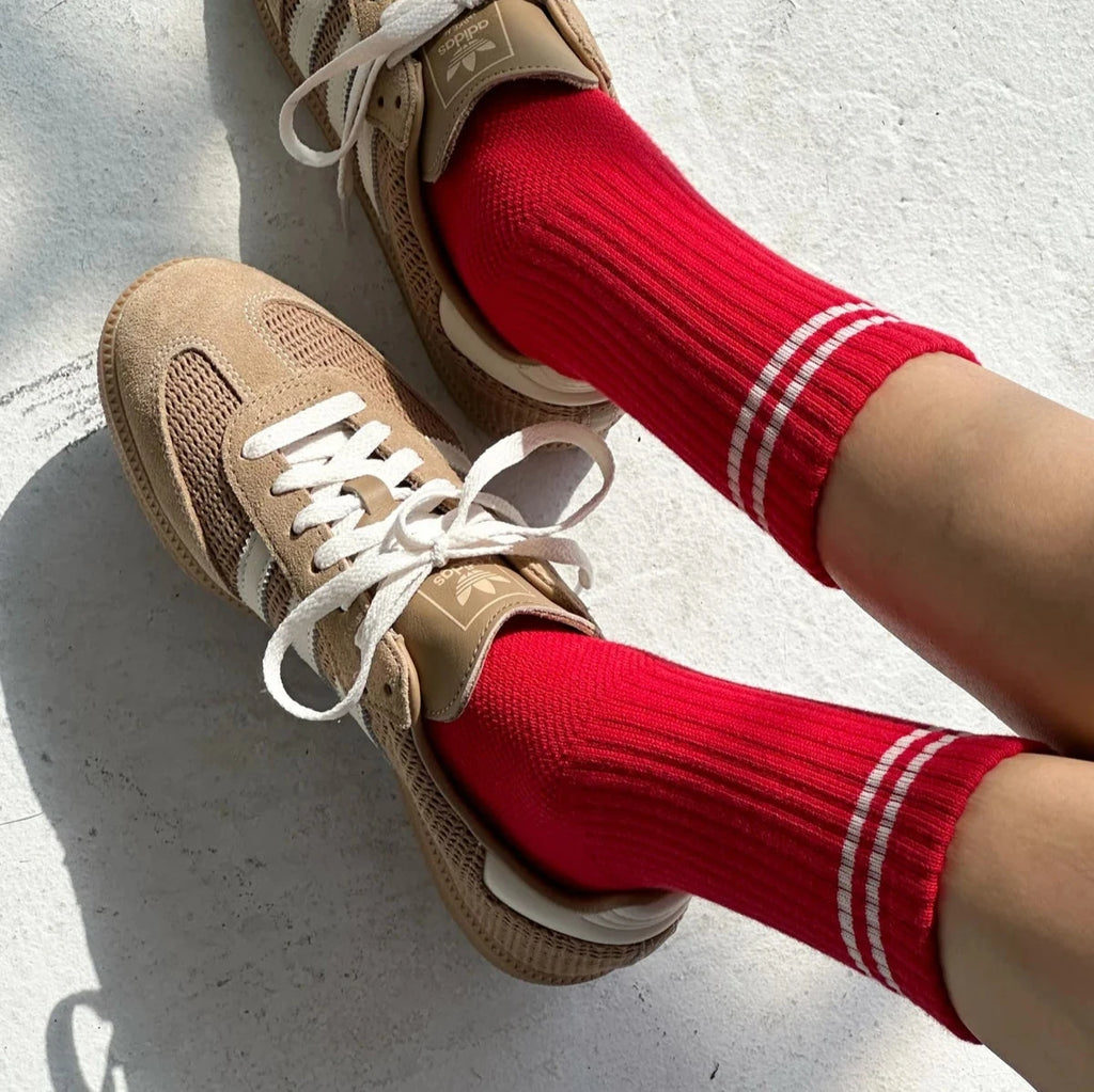 A person wearing the Boyfriend Socks in Red with tan gym shoes.